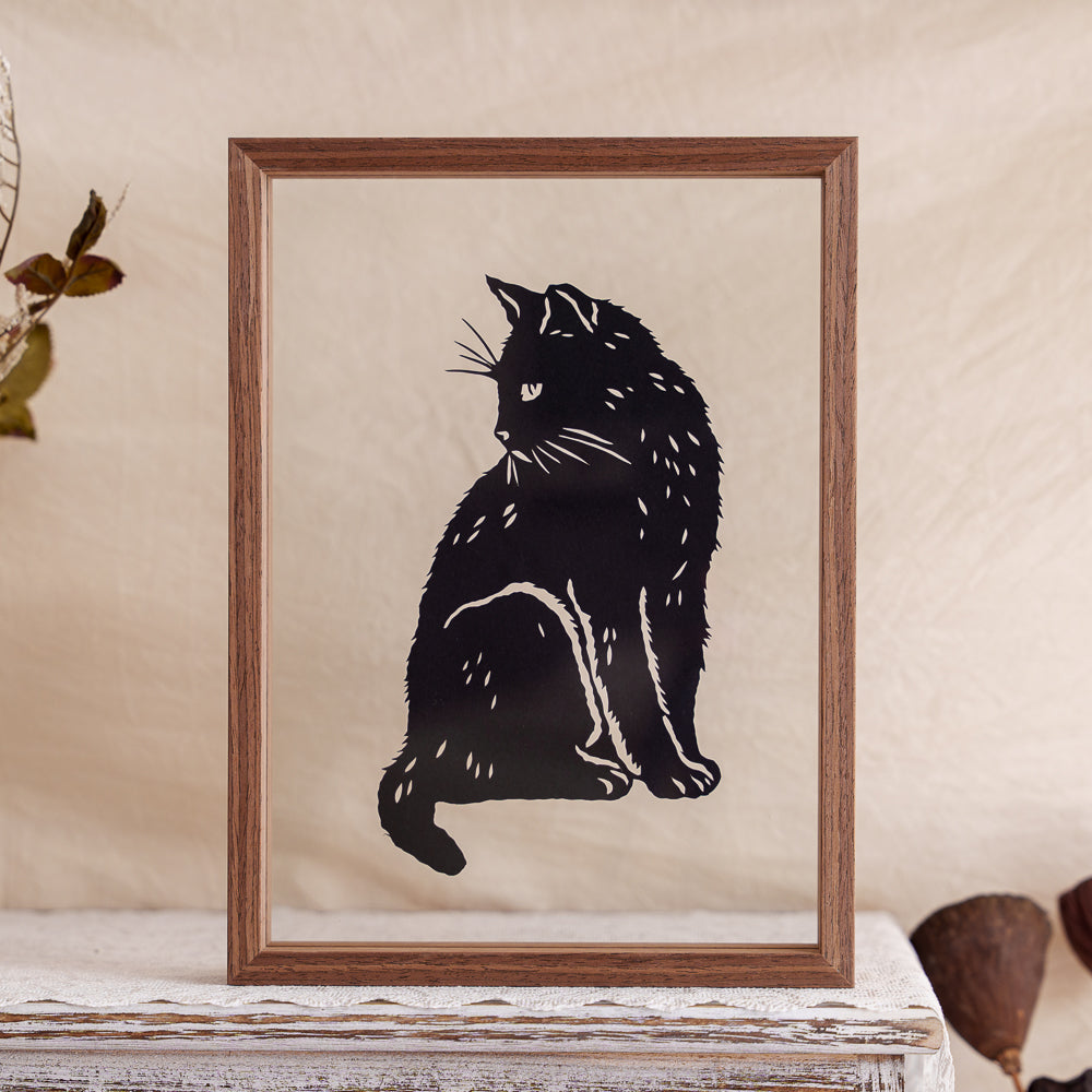 A cat silhouette memorial papercut displayed in a transparent frame