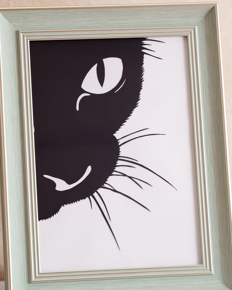 Hand-cut single-layer cat silhouette paper art showcasing intricate whisker details.