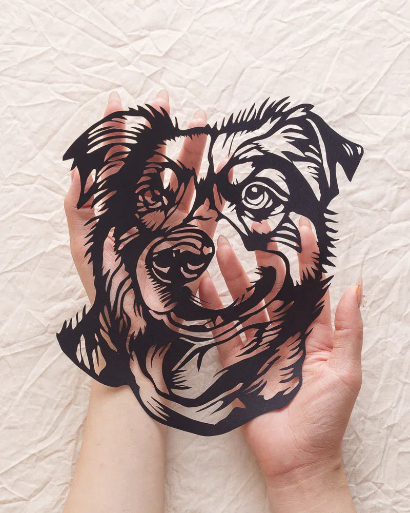 Cradling your dog's paper-cut portrait, fingertips find every lifelike fur ridge and nose wrinkle
