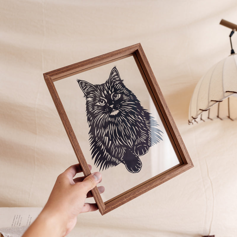 Artist holding a handmade Maine Coon cat silhouette papercut memorial, a unique and personalized keepsake for remembering a pet.