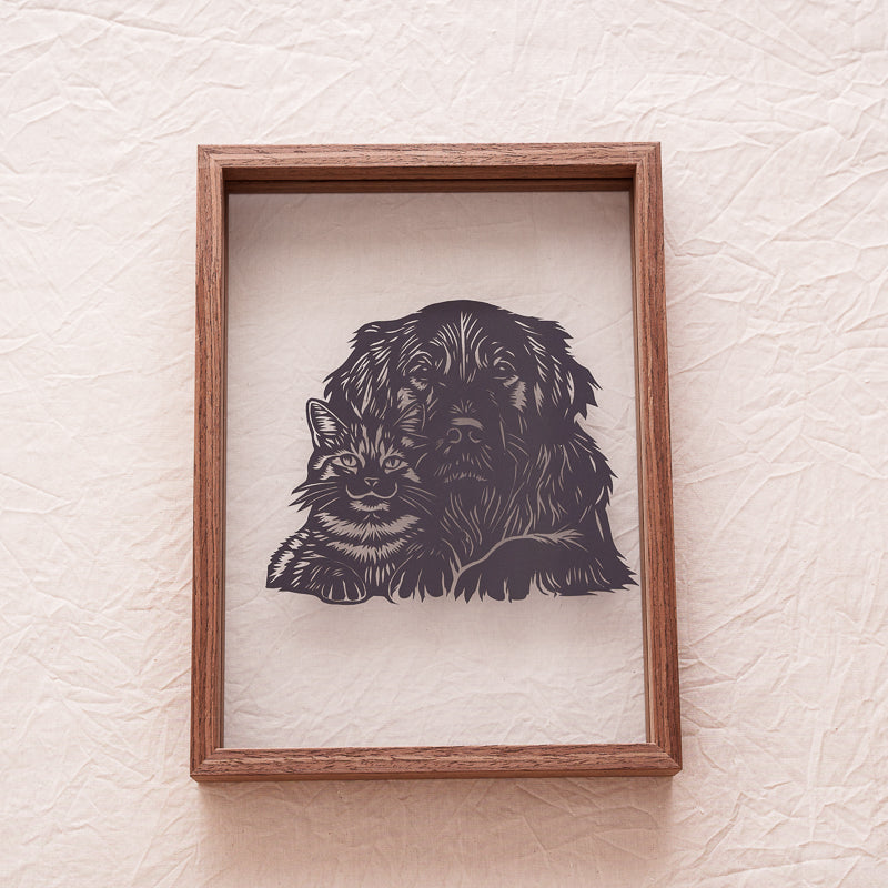 A cat and dog silhouette papercut memorial, representing love and unity between two beloved pets