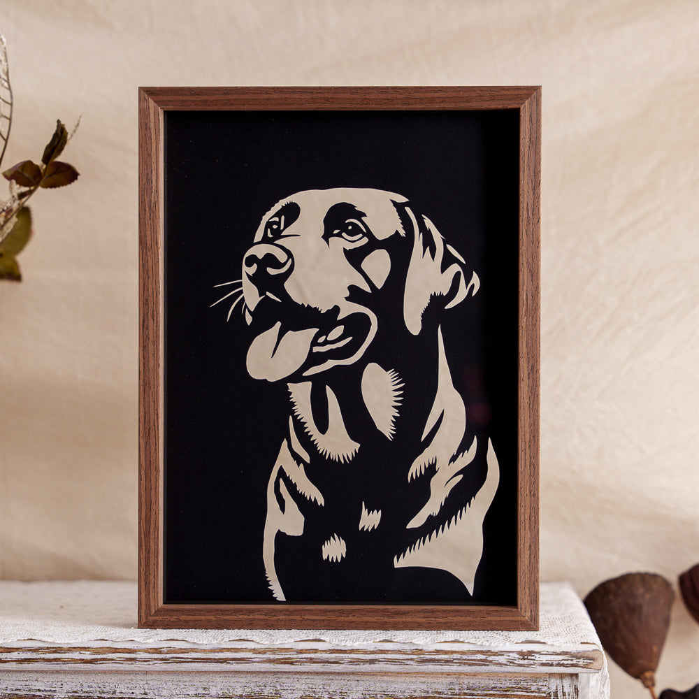 A memorial papercut of a Labrador, capturing its front-facing pose with an open mouth, as if panting gently.