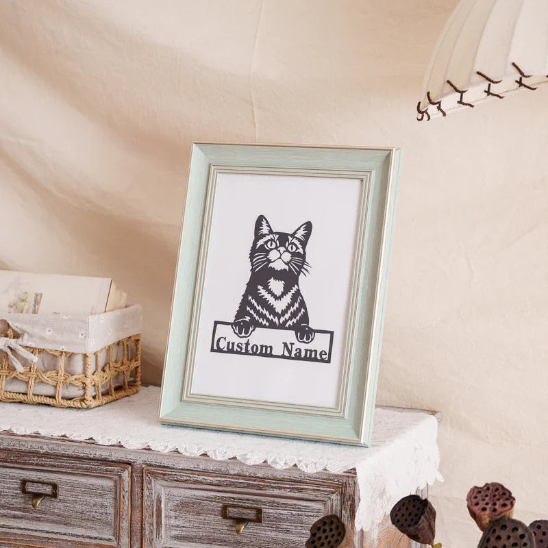 Handmade cat memorial paper cut art placed on living room shelf with books 