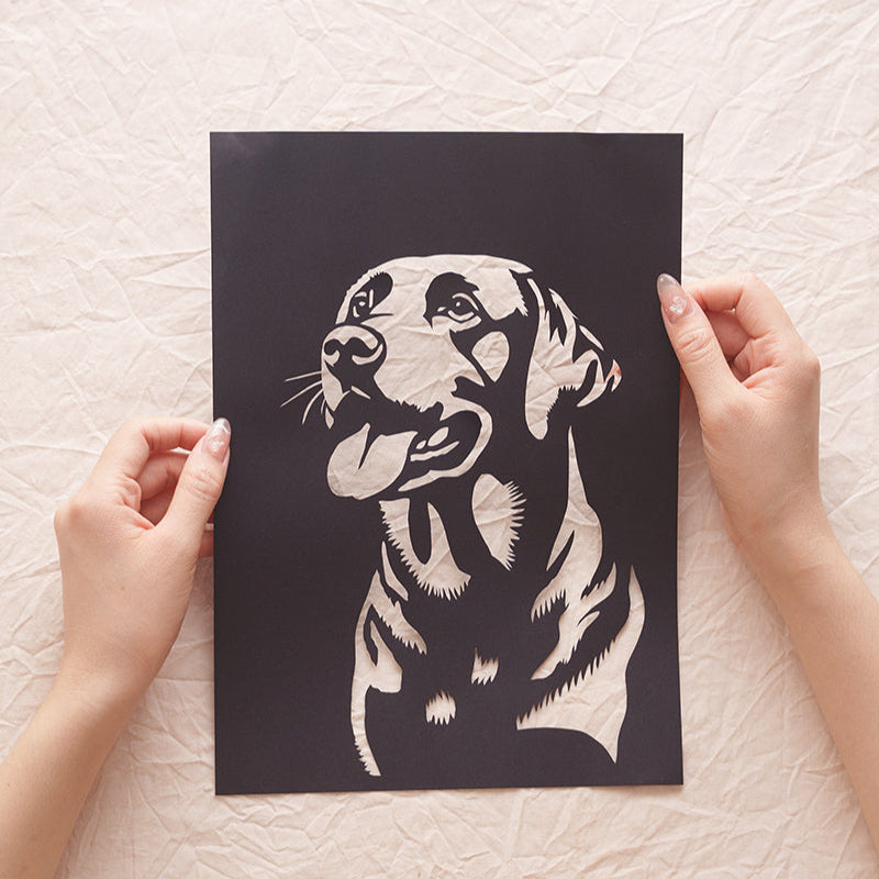 Hand holding a custom Labrador silhouette paper cut