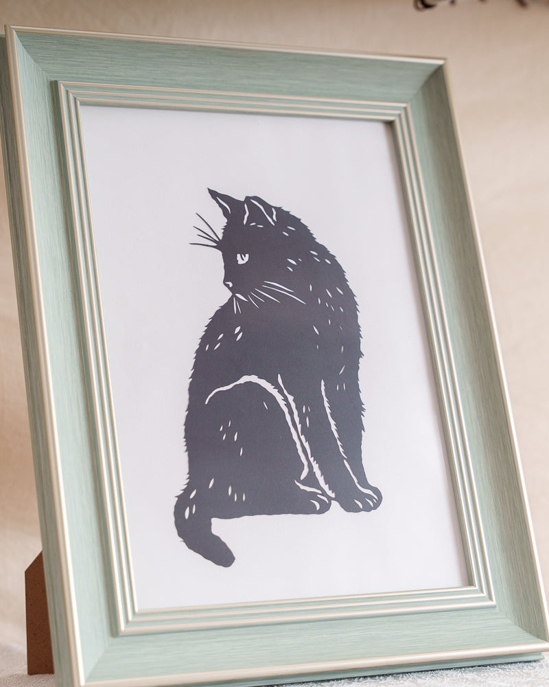 Close-up view showing the fine details of the handmade cat paper cut