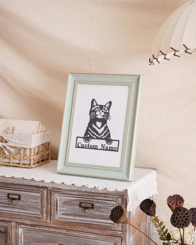 Handmade cat memorial paper cut art placed on living room shelf with books 