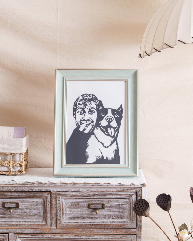 Framed pet-owner silhouette memorial displayed on living room shelf with natural wood accents