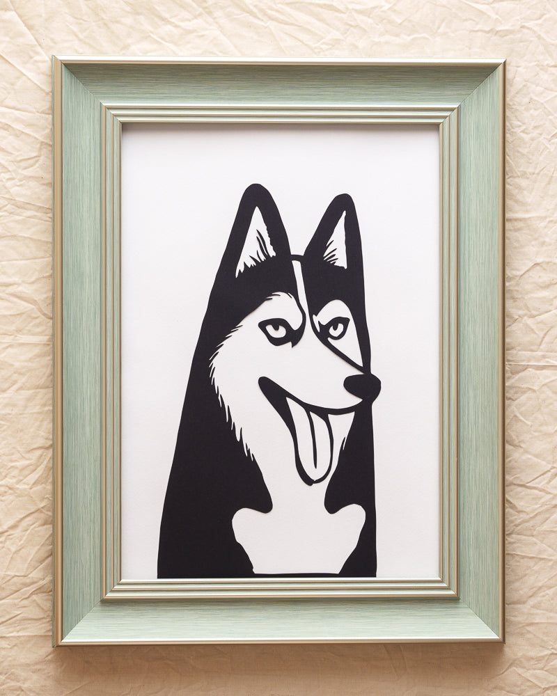 Hand-cut Siberian husky profile silhouette from single sheet black paper, traditional papercut technique