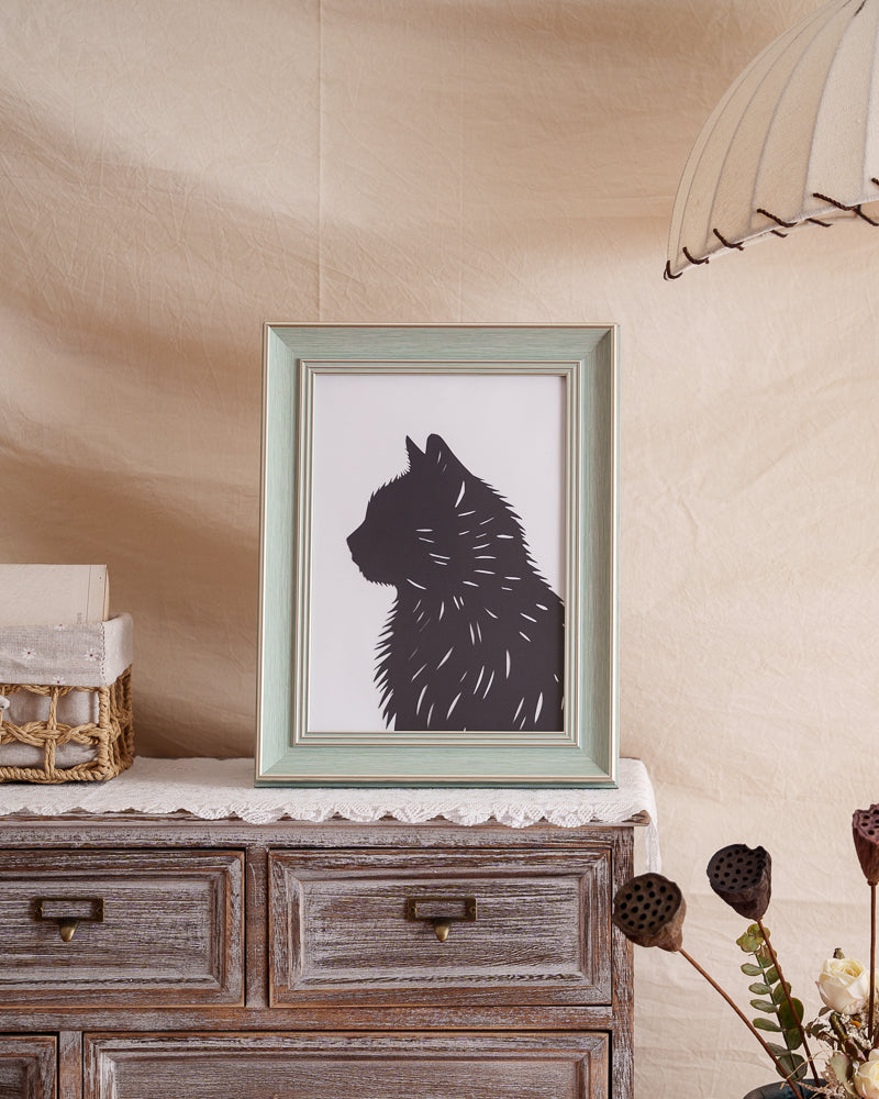 Stylish black cat silhouette artwork used as framed home decor on a shelf