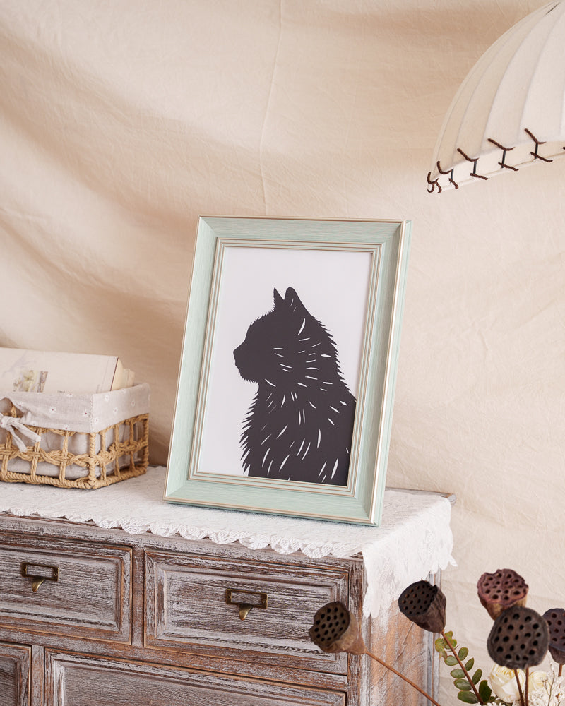 A framed, custom silhouette artwork of a beloved cat serving as a touching memorial piece and unique home decoration