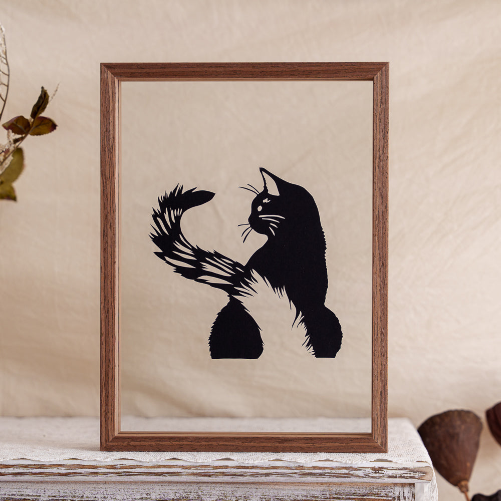 A memorial papercut artwork showing the backview of a cat with its tail playfully raised — a simple, heartfelt tribute to its quiet presence and charm.
