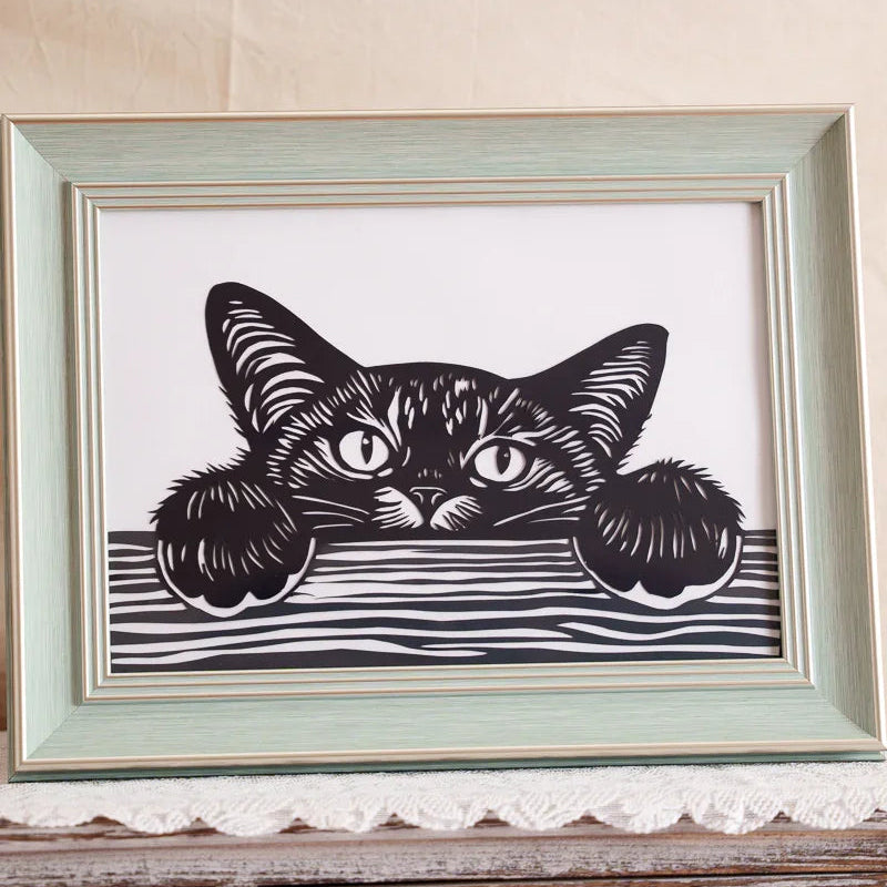 A close-up detail of a cat silhouette papercut artwork, showcasing the intricate craftsmanship and delicate lines.