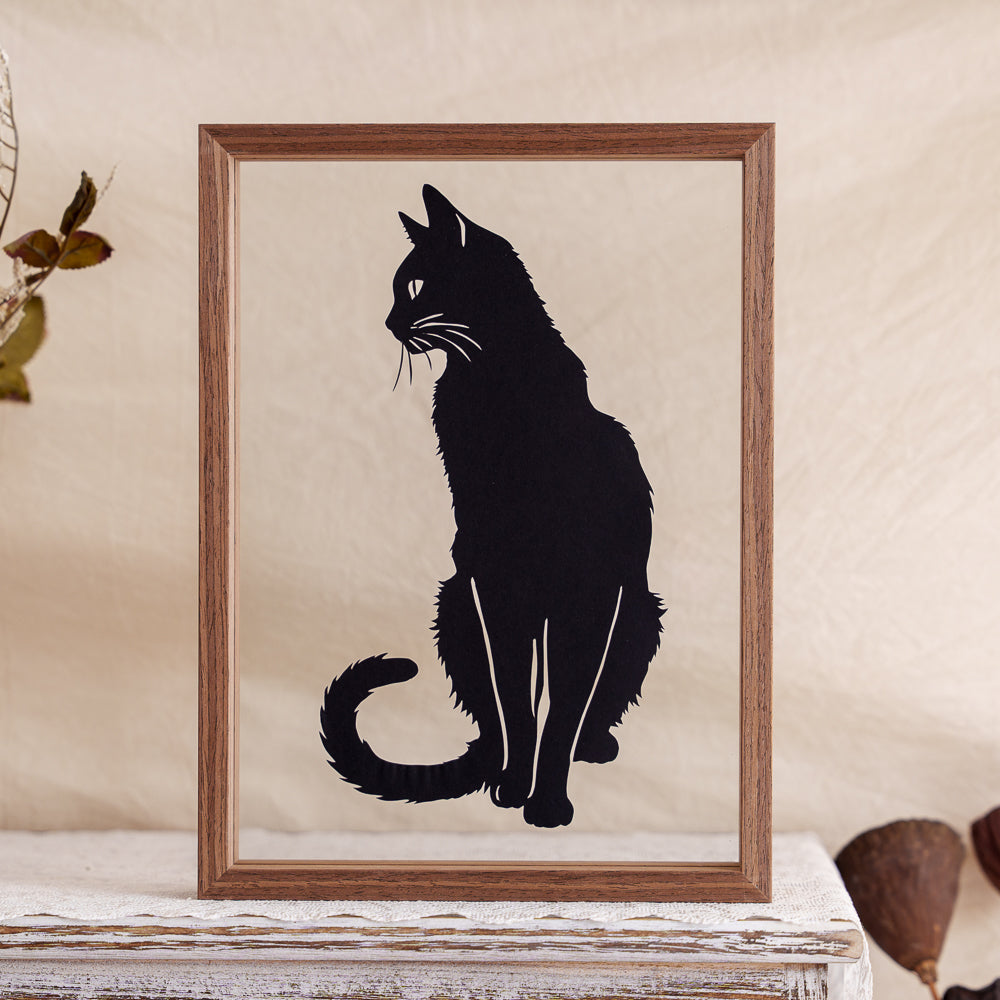 A handcrafted memorial papercut featuring a cat sitting gracefully.