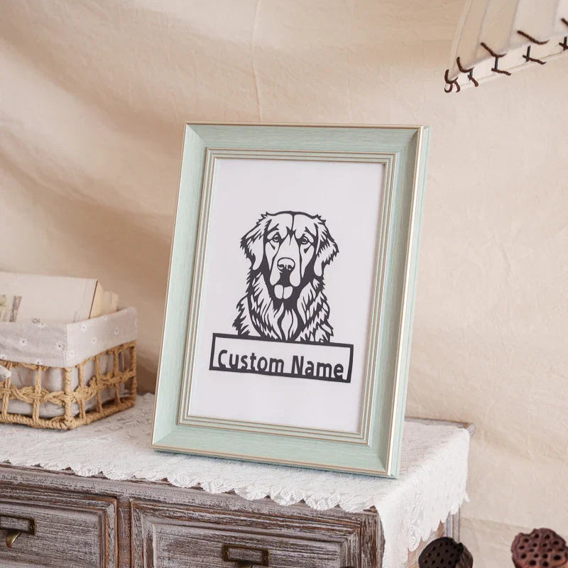 A handmade paper cut portrait of a beloved dog, displayed on a wooden sideboard beside plants and a ceramic bowl as a memorial home tribute