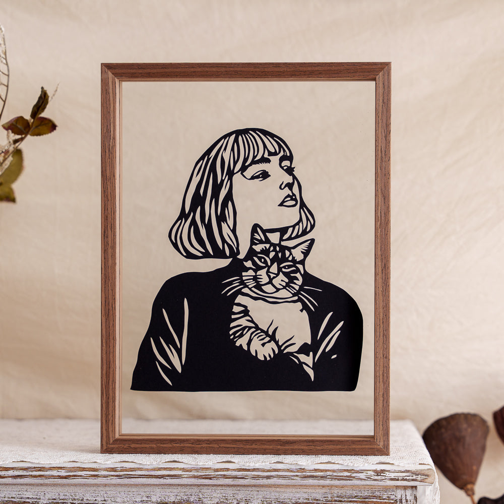 A heartfelt papercut artwork capturing the tender moment of an owner cradling their cat in their arms — a quiet tribute to love, comfort, and companionship.