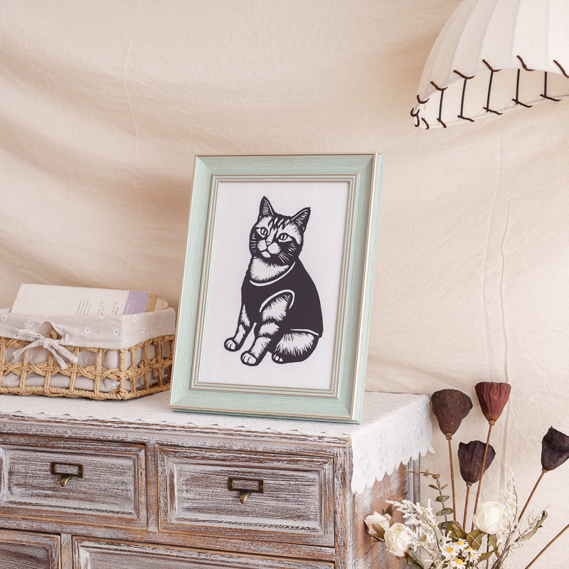 A cat silhouette papercut artwork placed as a memorial decor in a cozy home setting.