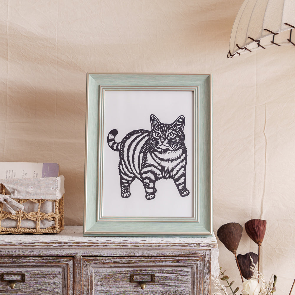 A cat memorial silhouette paper cut displayed on a shelf as decoration