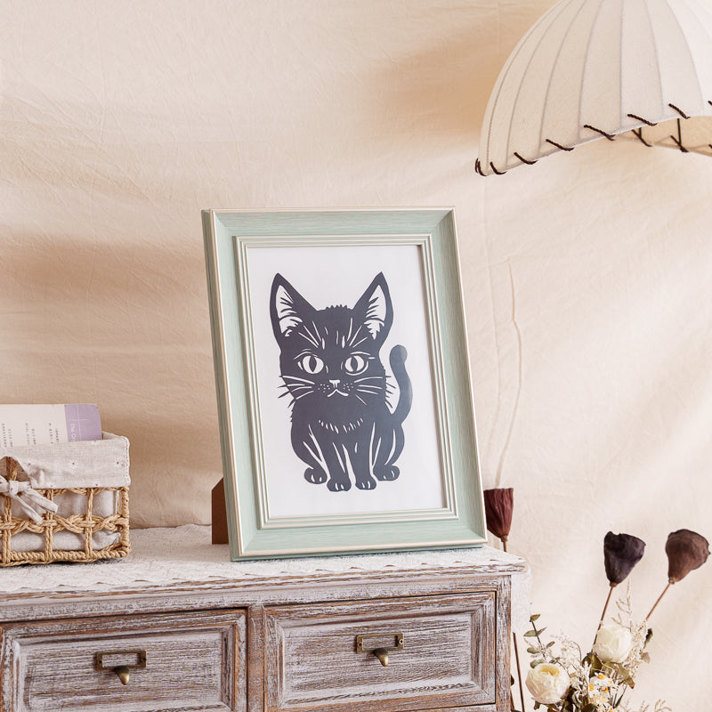 A framed cat memorial silhouette displayed on a cabinet as elegant home decor.