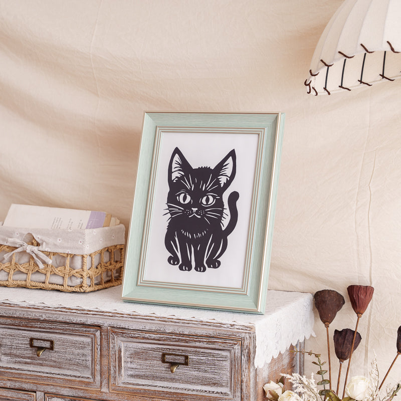 A papercut silhouette of a cat placed at home to memorialize a beloved pet.