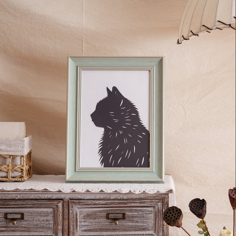 Stylish black cat silhouette artwork used as framed home decor on a shelf
