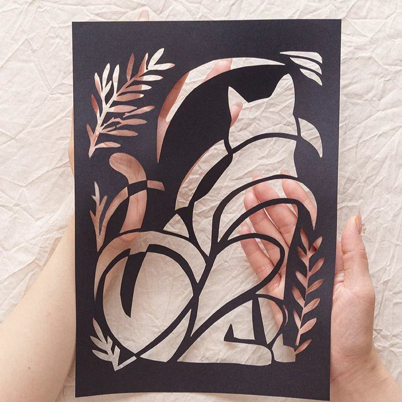 Holding my cat's memory catcher — this abstract silhouette paper-cut — right in my hands.
